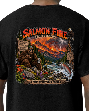 A black short-sleeve t-shirt shown from the back, featuring a large colorful graphic print with the text 'Salmon Fire Oregon' and an illustrated scene of a bear, a river, lightning, and a fish.