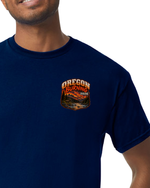 A man wearing a navy blue crewneck t-shirt with a 'OREGON BURNING 2026' graphic printed on the left chest.